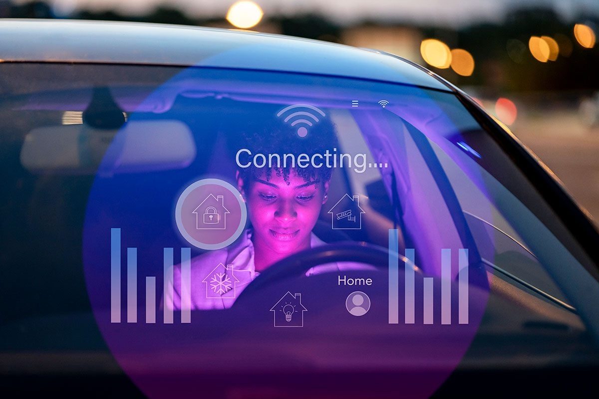 Businesswoman sitting in car with digital display on windshield